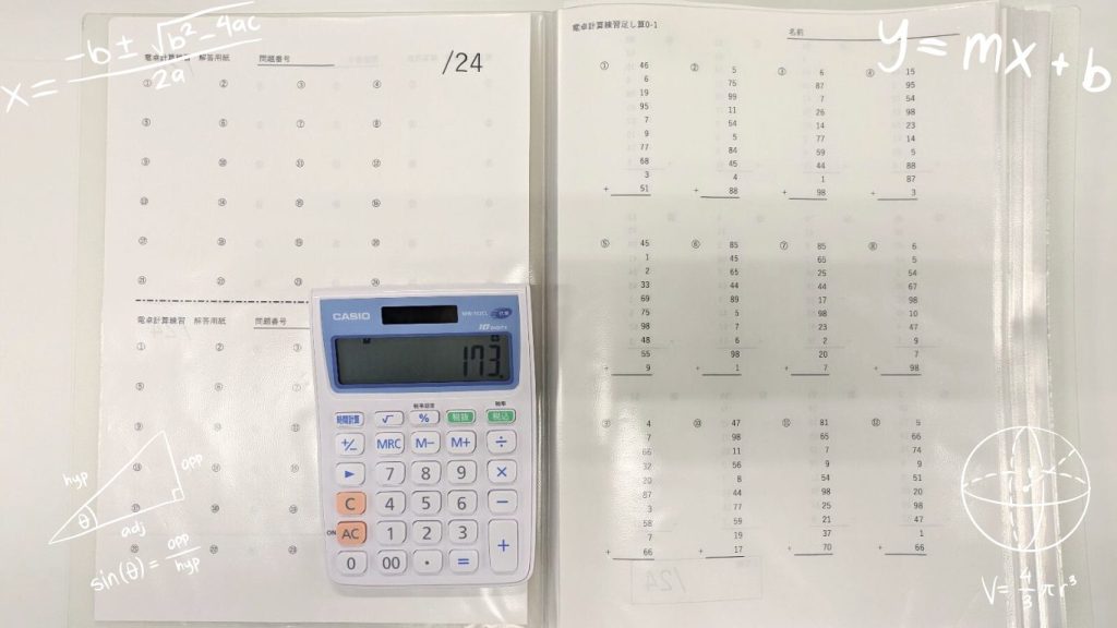 電卓計算のプログラムで使用する電卓と計算プリントの写真